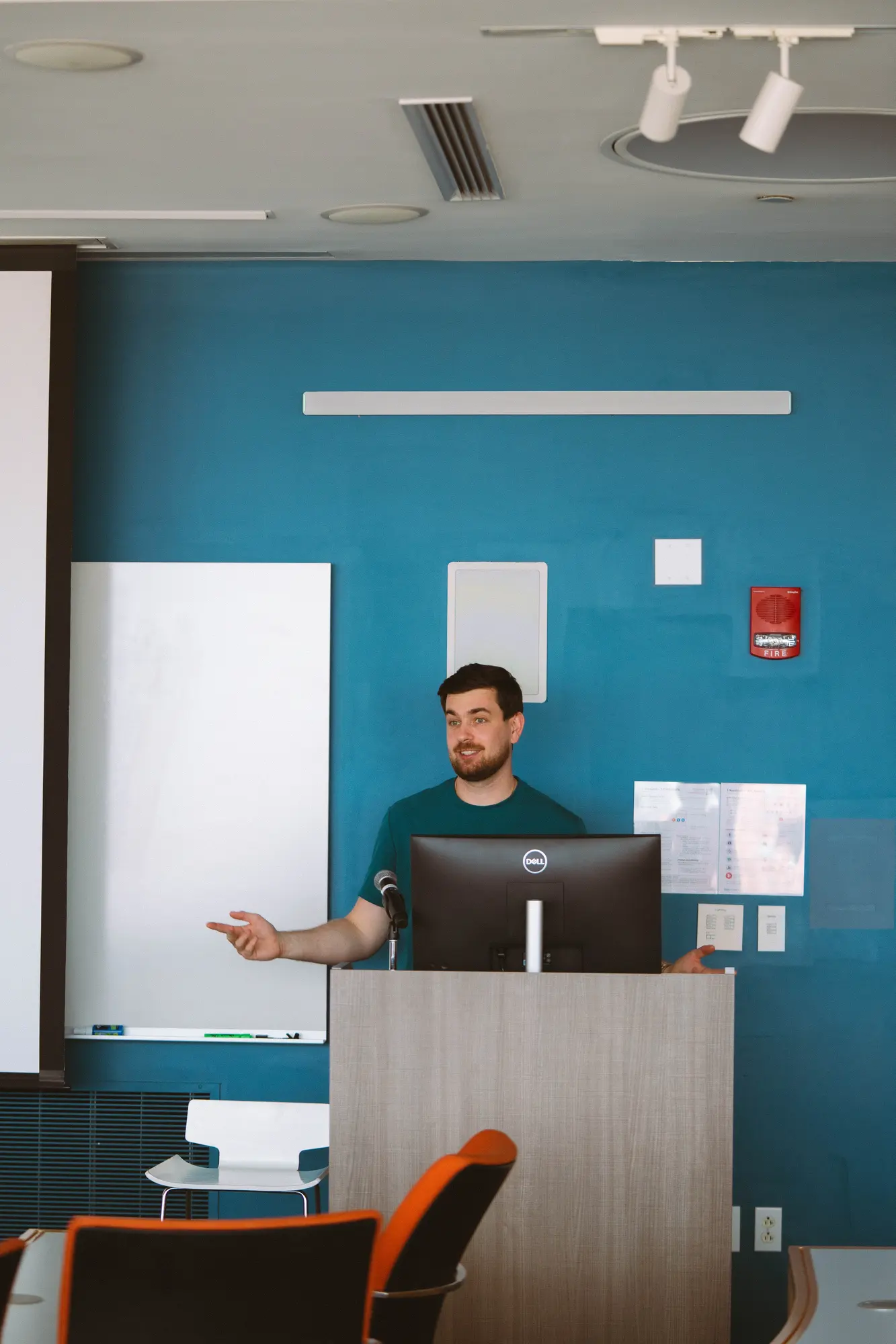 Dr. Volodymyr Kachmar leading a clinical education session at a lectern.